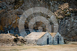 Turf house at foot of Drangurinn Rock in Southern Iceland. Eyjafjll mountains in southern Iceland near Ring Road, Route 1.