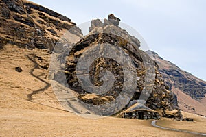 Turf house at foot of Drangurinn Rock in Southern Iceland. Eyjafjll mountains in southern Iceland near Ring Road, Route 1.