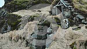 Turf house at foot of Drangurinn Rock in Southern Iceland. EyjafjÃ¶ll mountains in southern Iceland near Ring Road, Route 1.