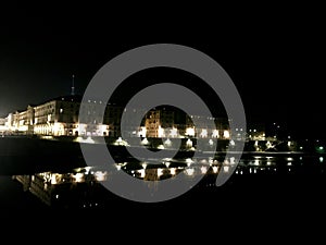 Turin by night, lights and mirrored city life, Italy.