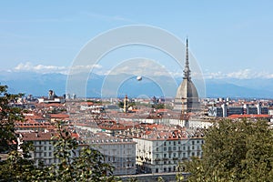 Turin rooftops view, Mole Antonelliana tower and hot air balloon in a summer day in Italy