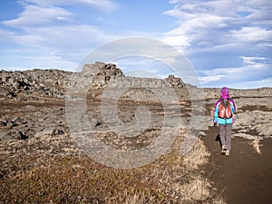 Turist girl among the typical basalt rocks in North Iceland