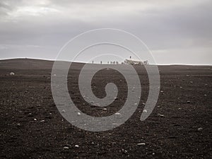 Turists on abandoned crashed plane in Iceland in black sand desert photo