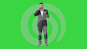 Turk business man in a suit making a call on a Green Screen, Chroma Key.