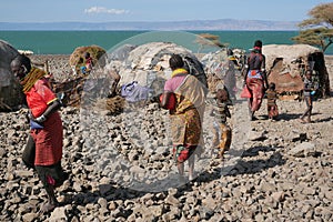 Turkana men and women living in patched huts on the stony shores of Lake Turkana