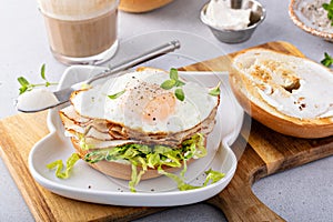 Turkey bagel breakfast sandwich with lettuce and fried egg