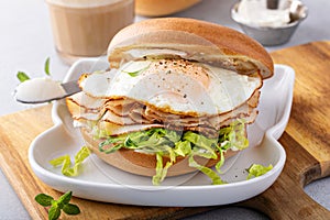 Turkey bagel breakfast sandwich with lettuce and fried egg