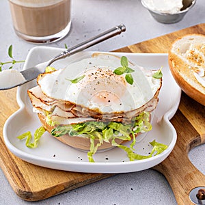 Turkey bagel breakfast sandwich with lettuce and fried egg