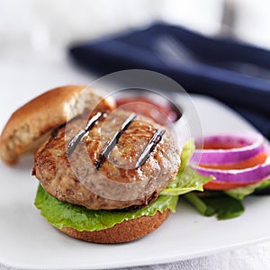 Turkey burger on bun with lettuce and fixings close up