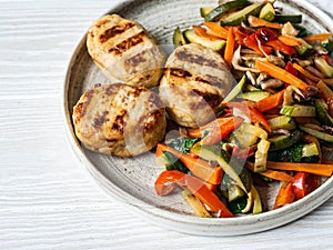 Turkey cutlets grill, vegetables steer fry on a plate on wood board table. Copy space