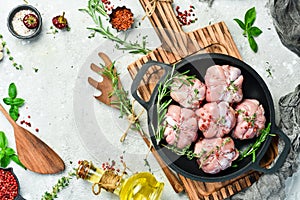 Turkey fillet with spices and rosemary in a pan, ready to cook. Barbecue. On a black concrete background.