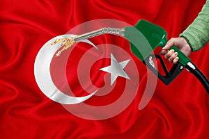 TURKEY flag Close-up shot on waving background texture with Fuel pump nozzle in hand. The concept of design solutions. 3d