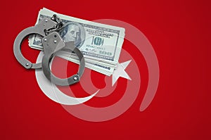 Turkey flag with handcuffs and a bundle of dollars. The concept of breaking the law and thieves crimes