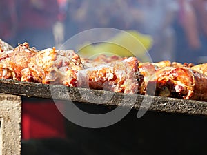 Turkey legs on top of hot charcoal grills at a festival
