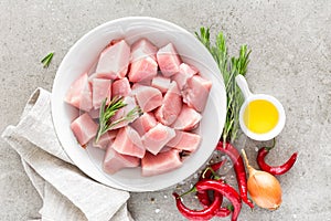 Turkey meat sliced and ingredients for cooking on light grey stone background