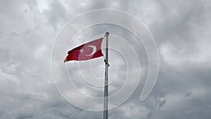 Turkey national flag blowing in strong wind with storm cloudy sky in the background