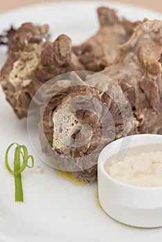 Turkey necks,  served with horseradish puree,  placed on white plate,  light background,  isolated