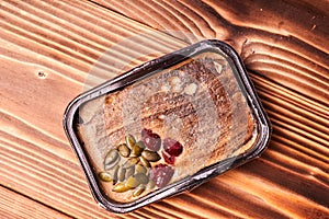 Turkey pate with pumpkin seeds and berries on a wooden table