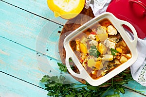 Turkey stew with pumpkin, vegetables and spices in a bowl on a wooden table in a rustic style.