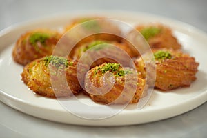 Turkish and Arabic Traditional Ramadan Dessert Lor Cheese Dessert with pistachio powder and syrup serving on plate.