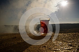 Turkish Azerbaijan tea in traditional glasse and pot outdoor nature background with sunlight and smoke. Eastern tea concept. Armud