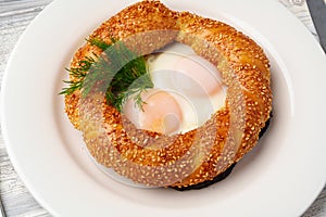 Turkish bagel simit and fried eggs on plate, Turkish breakfast