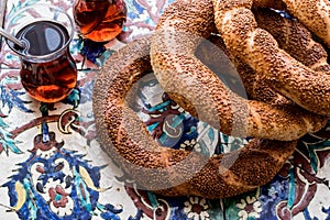 Turkish Bagel Simit with tea on ottoman pattern surface.