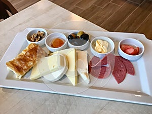 Turkish Breakfast Plate with Cheese, Various Jams, Salami, Borek and Dried Fruits.