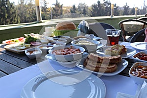 Traditional Turkish family breakfast table and people taking various food.