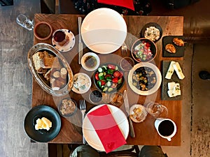 Turkish Breakfast Table with Tea, Coffee, Fresh Jams, Custard / Curd Cheese, Honey, Cream, Bagel and Bread.