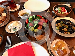 Turkish Breakfast Table with Tea, Coffee, Fresh Jams, Custard / Curd Cheese, Honey, Cream, Bagel and Bread.