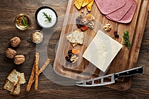 Turkish bryndza sheep milk cheese on wooden table with wooden cutting board and knife