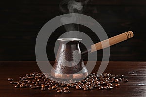 Turkish coffee in cezve and beans on wooden table