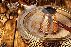 Turkish coffee in cezve on the sand photo