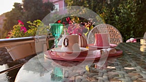 Turkish coffee cups served outside with water flowers and delight dessert in romantic setup on glass table