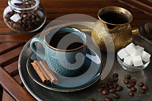 Turkish coffee. Freshly brewed beverage served on wooden table, closeup