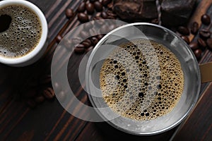 Turkish coffee pot with hot drink and beans on wooden table, flat lay. Space for text