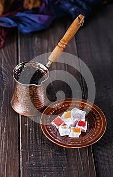 Turkish coffee and Turkish Delight over dark wooden background