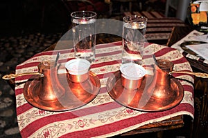 Turkish coffee and turkish delights. Cup of arabic coffee and glass of cold water. Traditional turkish coffee in a pot.