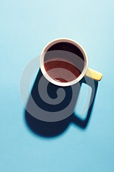 Turkish coffee in a yellow mug on blue background