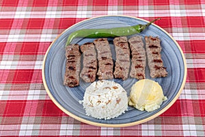 Turkish cuisine inegol meatballs. Grilled meatballs on a plate. Turkish Tekirdag or inegol Kofte with pepper, rice and mashed