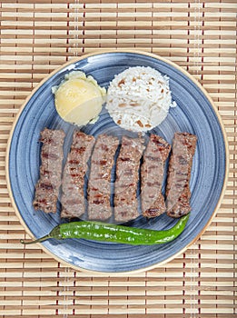 Turkish cuisine inegol meatballs. Grilled meatballs on a plate. Turkish Tekirdag or inegol Kofte with pepper, rice and mashed