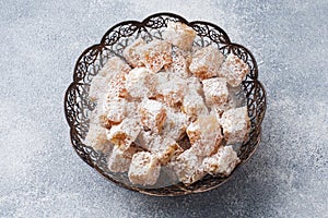 Turkish delight with hazelnut in carved metal bowl, selective focus