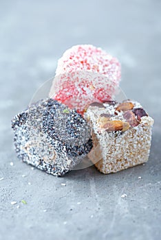 Turkish delight - lokum or rahat lokum with poppy on grey background. Traditional eastern cuisine. Traditional middle