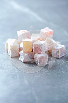 Turkish delight - rahat lokum or lokum with sugar powder on grey background. Traditional eastern cuisine. Traditional