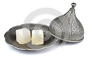 Turkish delight in traditional Ottoman style carved patterned metal plate isolated on white background