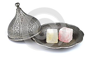 Turkish delight in traditional Ottoman style carved patterned metal plate, isolated on white background