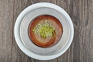 Turkish dessert kunefe, kunafa, kadayif with pistachio powder and cheese hot eaten a sweet