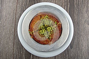 Turkish dessert kunefe, kunafa, kadayif with pistachio powder and cheese hot eaten a sweet