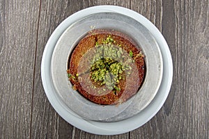 Turkish dessert kunefe, kunafa, kadayif with pistachio powder and cheese hot eaten a sweet photo